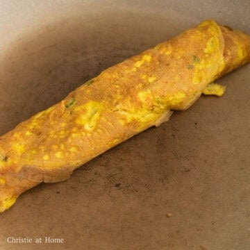 Then roll the egg roll all the way through so the flap sticks to the rest of the roll.