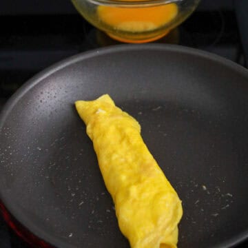 Allow the eggs to set until 75 % cooked and roll the pancake into a 1-inch wide roll.