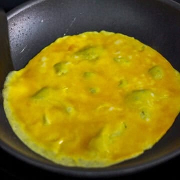 Then in a small bowl, beat eggs with ¼ teaspoon salt. Heat 1 teaspoon vegetable oil in a small non-stick pan (around 7-8 inches wide) on medium heat, pour in half of the beaten eggs to create a thin pancake.