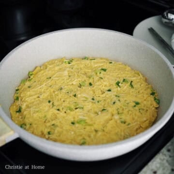 Heat 2 tablespoon of vegetable oil in a large non-stick pan on medium heat. Add half of the pancake batter into the pan and spread it evenly into a circle with a spatula. Fry until the bottom becomes golden brown, about 5-7 minutes.