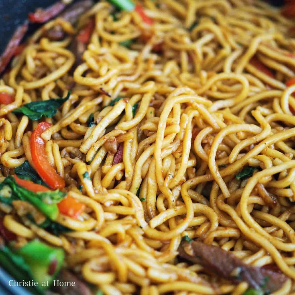 Toss in bell peppers, gai-lan, garlic and green onions and stir fry for 1 minute. Add noodles, noodle sauce and toss everything together until the sauce has caramelized and most of the sauce has absorbed into the noodles. Serve and enjoy!