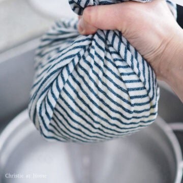 Transfer the grated potatoes into a clean tea towel and wring out as much water as possible. The drier the potatoes are, the more crispy your pancakes will be.