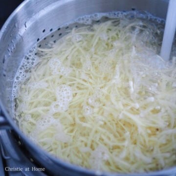 Rinse the grated potatoes with cold running water to remove excess starch. Strain out the excess water by giving the colander a good shake.