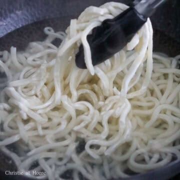 Fill a large pan or wok halfway with water and bring to boil on medium-high heat. Blanch frozen udon noodles just until loosened for 20 seconds. Do not boil them or they will become soggy when you stir-fry them. If you're using non-frozen udon noodles, you can skip this step.