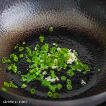 Heat vegetable oil in a large pan on low-medium heat and fry garlic and green onions until fragrant, or about 10 seconds.