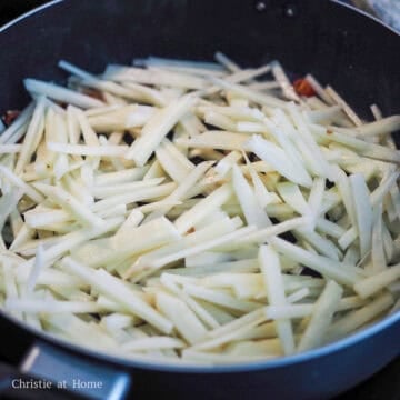 Toss in thinly sliced potatoes with aromatics.