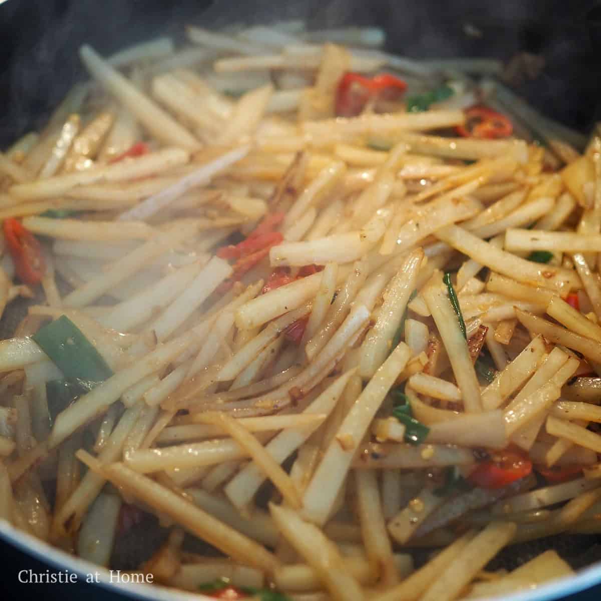 Season potatoes with salt, regular soy sauce, sugar, and sesame oil. Mix well. Cook for 7-9 minutes until potatoes are tender to taste. At the 7 minute mark, taste test the potatoes to check if they're tender enough and if they're not ready, continue cooking until they are. Lastly, toss in green onions and season with white vinegar and remove off heat. Serve hot and enjoy!