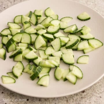 Slice cucumbers into quarter long vertical strips and then slice strips into ¼-inch thick wedges. Spread sliced cucumbers on a large plate and sprinkle salt over top and let this rest for 15-20 minutes.