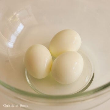 Meanwhile, bring a small pot of water to boil and lower your eggs. Boil uncovered for 8 minutes. Once boiled, transfer boiled eggs into an ice bath. Crack and peel eggs and transfer them to a large bowl.