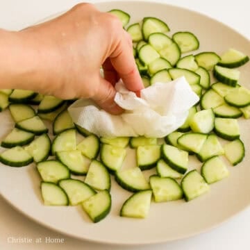 Then pat dry the cucumbers with clean paper towels to remove as much excess water as possible. This process makes the cucumbers crunchier.