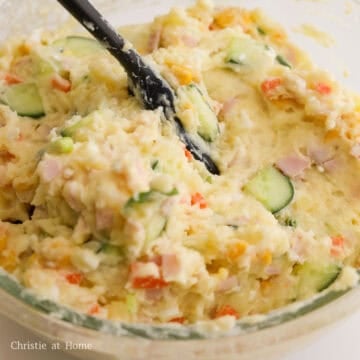 Then add cucumbers, ham, carrots, corn, green onions, Kewpie mayo, salt and sugar to the potato mixture. Combine everything together with a spatula. Chill for at least 1 hour or if you'd like, enjoy immediately.