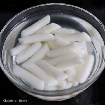 Soak cold rice cakes in warm water for 5 minutes to bring them to room temperature. Strain and set aside.