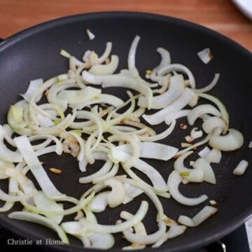 Heat vegetable oil in a large 11 to 12-inch pan on medium heat. Sauté sliced onions for 60 seconds or until slightly browned on the edges. Then evenly spread them across the pan in a single layer.