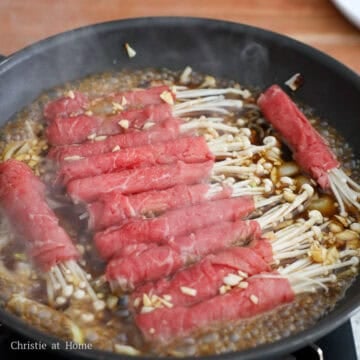 Carefully place the beef enoki rolls in a single layer across the pan in a line. Pour the broth into the pan. Cover and simmer for 3-5 minutes until the enoki beef rolls are about 95% cooked.