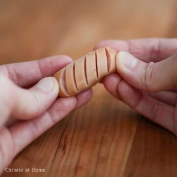 Using a sharp knife, make 3-5 shallow cuts on each mini sausage on one side only. Avoid slicing deeply. Tip: slice 4 sausages at the time for faster preparation.