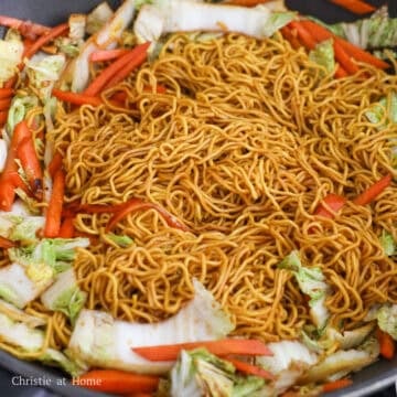 Add another 1 tablespoon (15 mL) vegetable oil into the pan. Stir fry the carrots and cabbage for 30 seconds and push to the side of the pan. Then add remaining vegetable oil into the empty space. Add noodles and noodle sauce and toss until evenly coated and there is little sauce on the base of the pan.