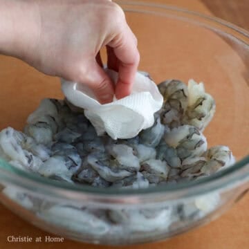 Transfer shrimp to a large bowl after it's peeled, deveined and rinsed with cold water. Pat dry with paper towels to remove excess moisture.