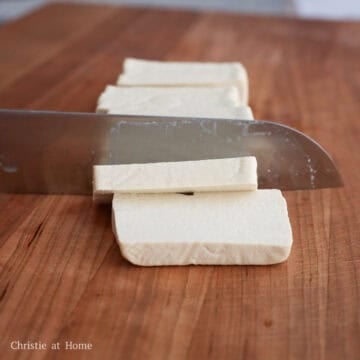 Drain the block tofu of its packaged liquids. Then slice the block tofu into 2.5-inch-long rectangles that are â…“-inch thick.