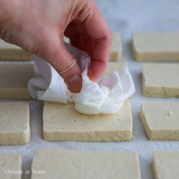 On a large baking sheet or plate lined with paper towel, place tofu slices flat in a single layer. Pat dry tofu with more paper towel.Â