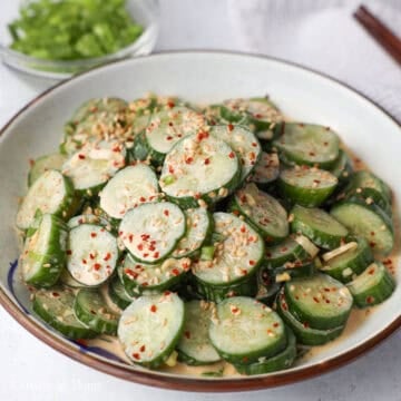 Mix the dressing into the sliced cucumbers and transfer to a serving plate. Garnish with sesame seeds. Serve and enjoy immediately.